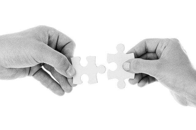 Ľudia dávajú dokopy dve kocky z puzzle.jpg